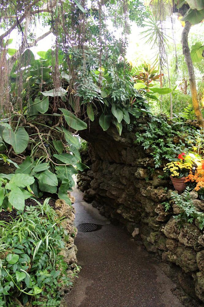 A stone tunnel covered in foliage and flowers at the Phipps Conservatory. Photo by Allyn Reynolds.