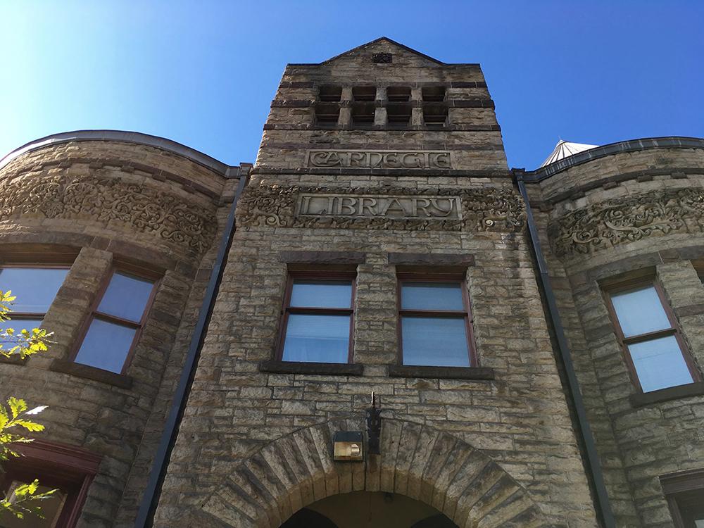 Looking up the Carnegie Library in Braddock. There’s a blue sky and the front of the building. Photo by Arielle Berk.