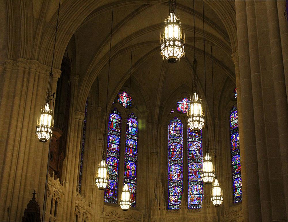 Stained glass and lamps in sanctuary. Photo by Emilia Del Vecchio, 2023.