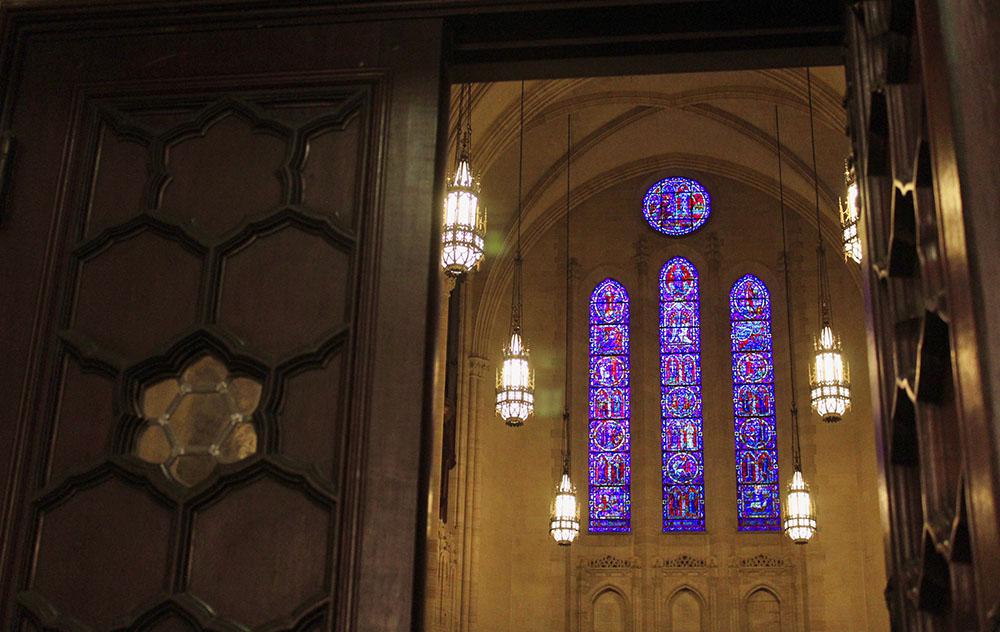 Stained glass and chandeliers as seen through door. Photo by Emilia Del Vecchio, 2023.